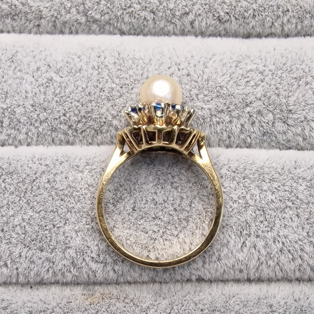 9 CT Gold Ring. One pearlescent & 8 turquoise coloured stones. - Size N